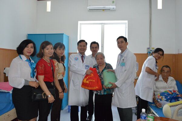 Đại tá, Thầy thuốc Ưu tú Trương Hoàng Việt, Giám đốc Bệnh viện Quân dân y miền Đông (thứ 4, bên trái) tặng quà động viên bệnh nhân điều trị tại bệnh viện.