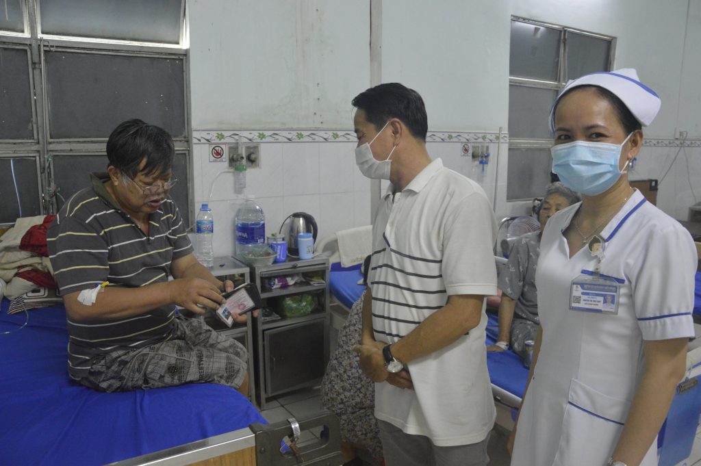 Anh Phạm Đình Công trả lại tài sản cho ông Phạm Đình Hào trước sự chứng kiến của nhân viên bệnh viện và bà con xung quanh.